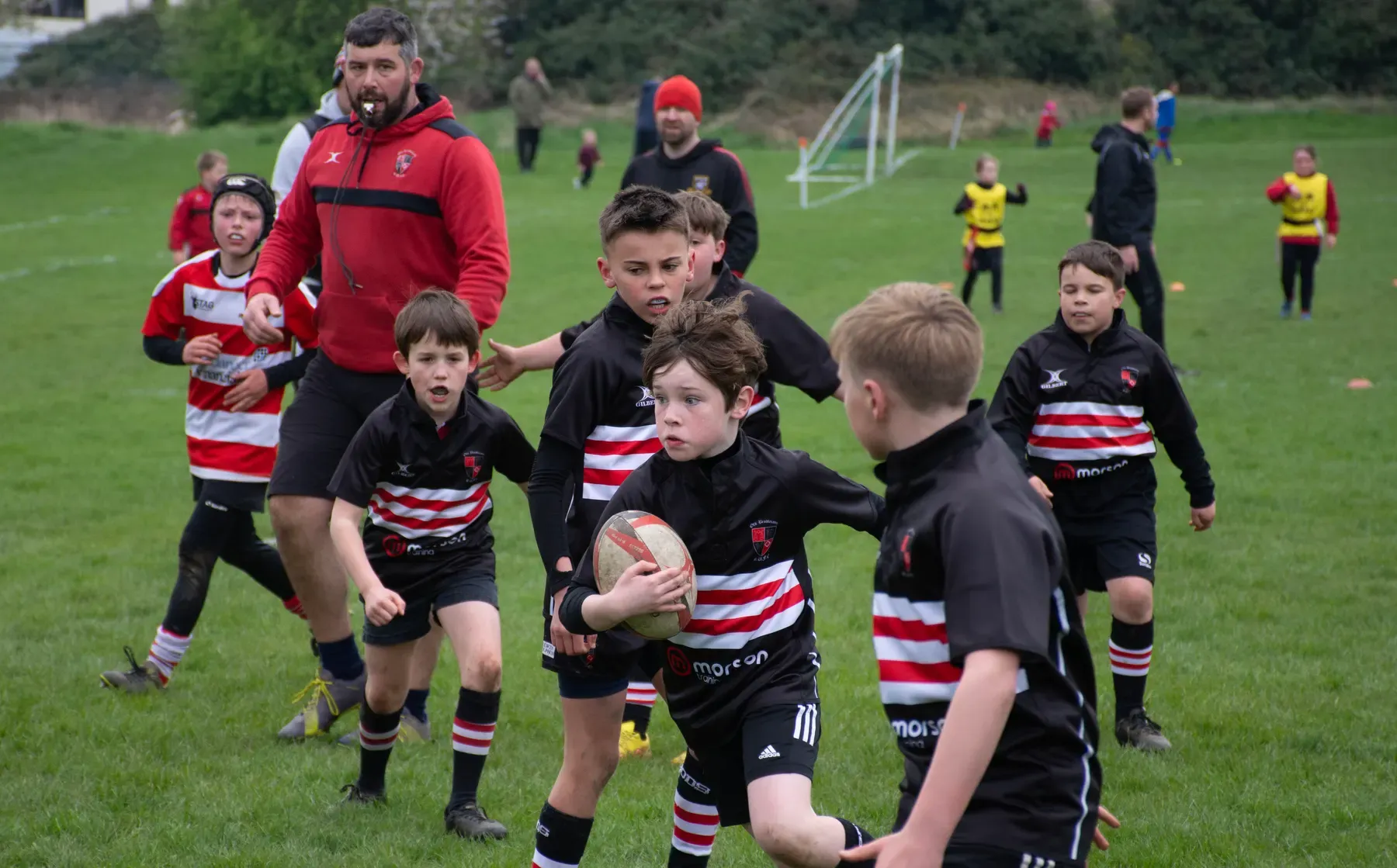 A coach and young Old Brodleians players during rugby training.