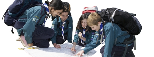 Scouts wearing backpacks work together to read a map.